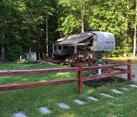 rv parked on site with grass and trees